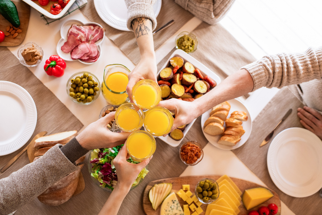 People Holding Orange Juice Filled Drinking Glasses